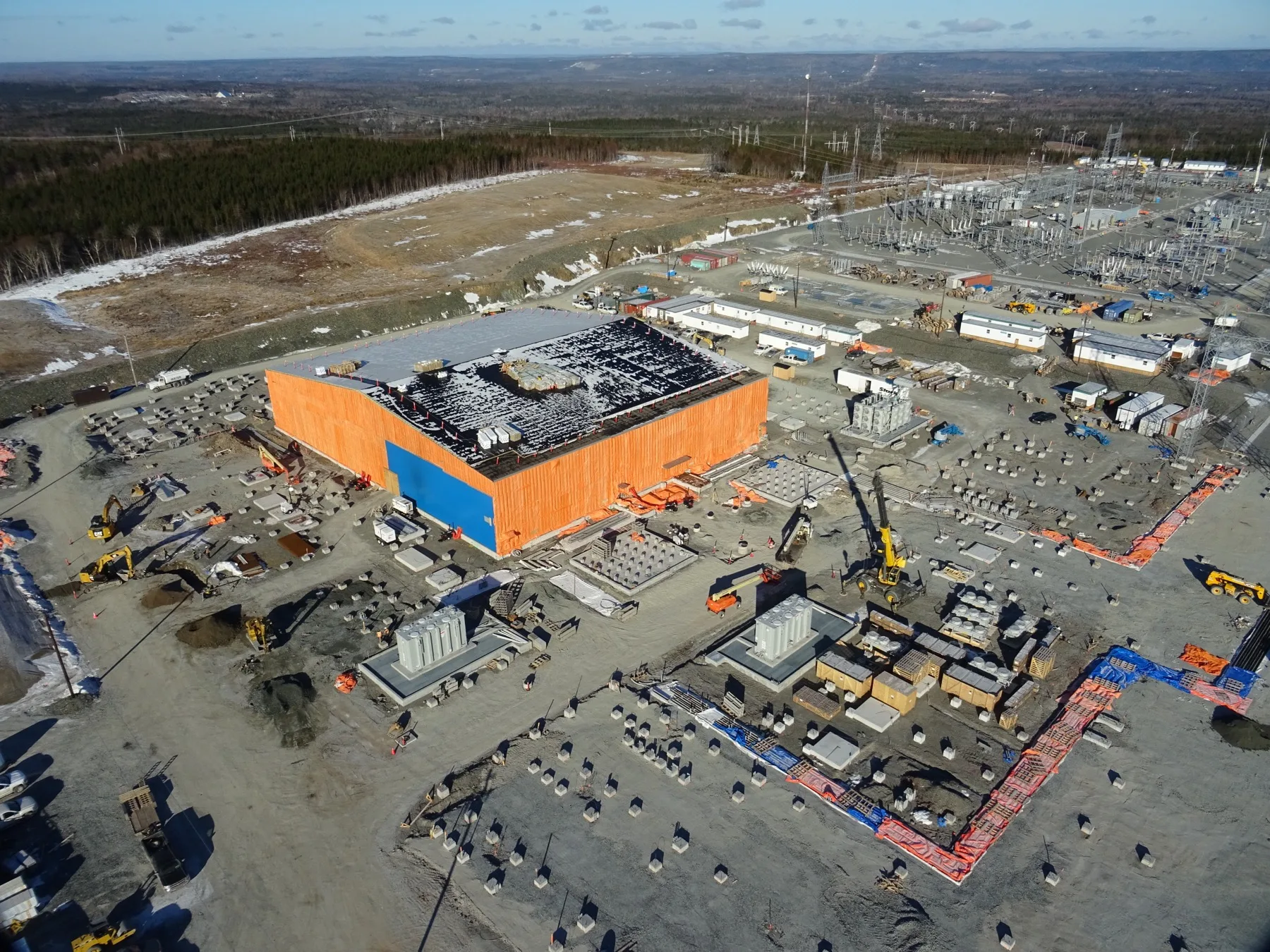 Aerial view of substation building and foundation works on a cleared site, Newfoundland